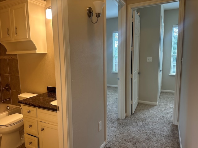 bathroom with a wealth of natural light, vanity, and toilet