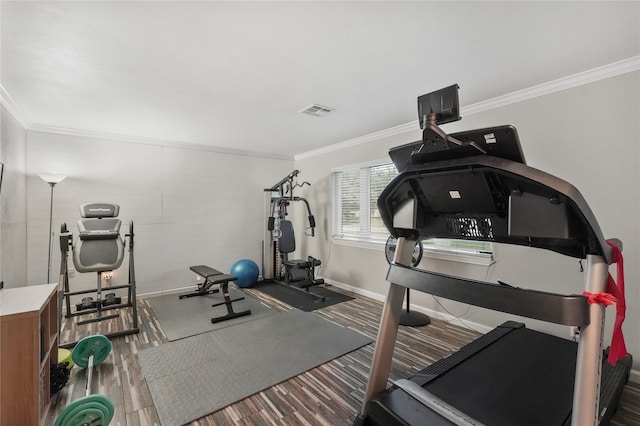 workout area with hardwood / wood-style floors and ornamental molding