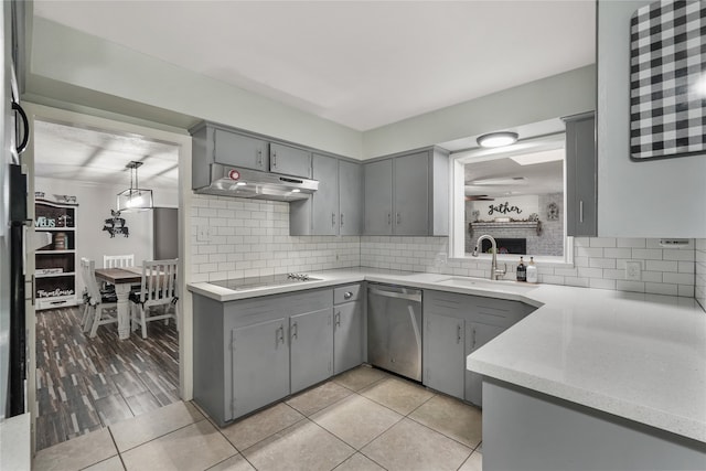 kitchen with black electric stovetop, stainless steel dishwasher, gray cabinetry, sink, and pendant lighting