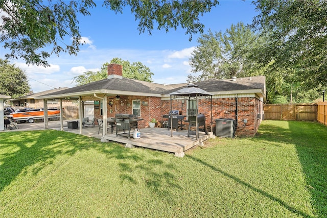 back of property with a gazebo, central AC unit, a deck, and a yard