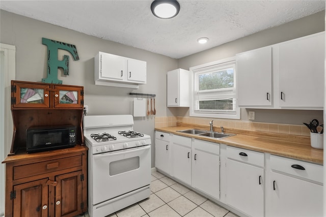 kitchen featuring sink, white cabinets, white range with gas stovetop, a textured ceiling, and light tile patterned flooring