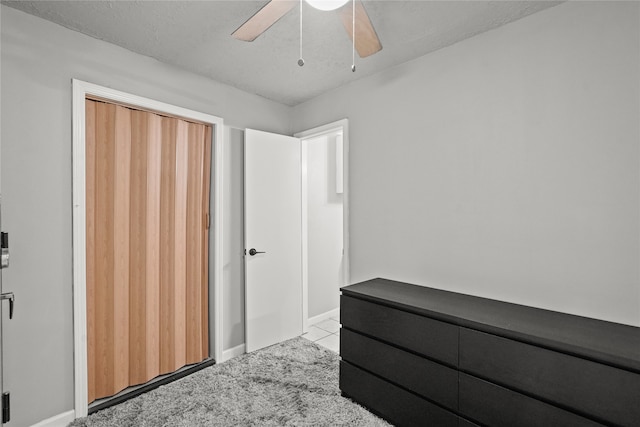 carpeted bedroom featuring ceiling fan, a textured ceiling, and a closet