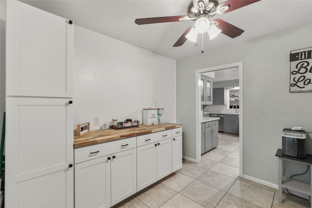 kitchen featuring decorative backsplash, ceiling fan, white cabinets, butcher block countertops, and light tile patterned flooring