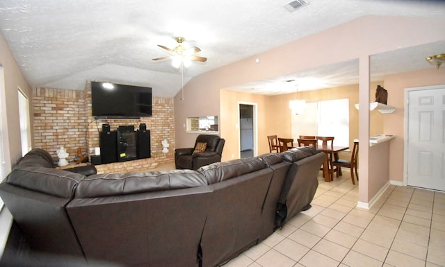 living room with ceiling fan, light tile patterned floors, a textured ceiling, and vaulted ceiling