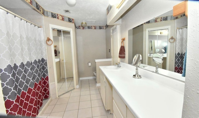 bathroom featuring a textured ceiling, walk in shower, tile patterned floors, vanity, and toilet