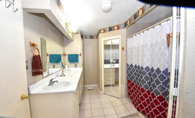 bathroom with a textured ceiling, tile patterned flooring, vanity, and a shower with shower curtain