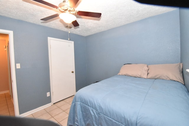 tiled bedroom featuring ceiling fan and a textured ceiling