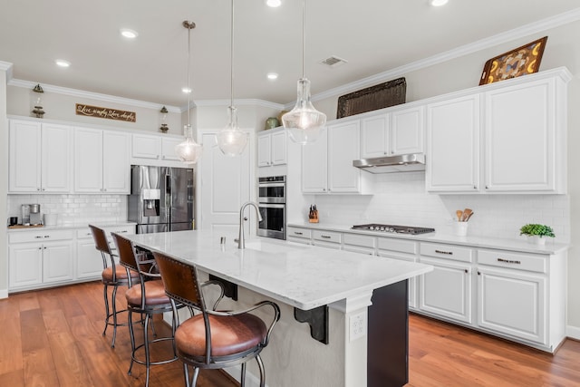 kitchen featuring stainless steel appliances, white cabinetry, and hanging light fixtures