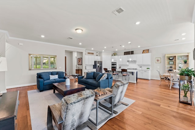 living room featuring light hardwood / wood-style flooring and crown molding