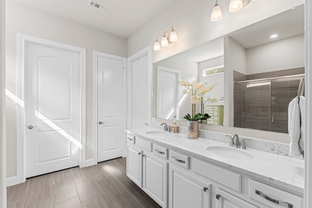 bathroom with a shower with door and vanity