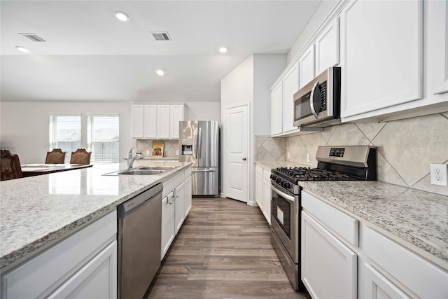 kitchen with white cabinets, backsplash, and stainless steel appliances