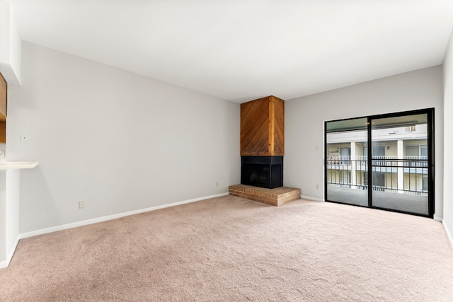 unfurnished living room with carpet flooring and a fireplace