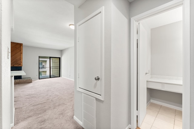 hallway featuring light colored carpet