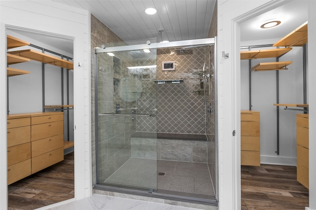 bathroom with wood-type flooring and an enclosed shower