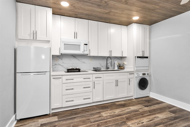 kitchen with stacked washer and clothes dryer, white appliances, white cabinetry, and dark hardwood / wood-style floors