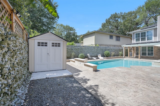 view of swimming pool with a patio and a shed