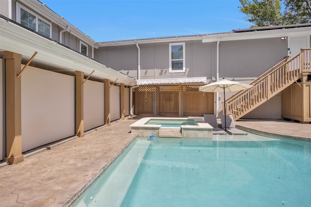 view of pool featuring a patio and an in ground hot tub