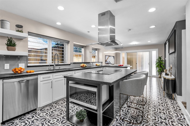 kitchen featuring white cabinetry, a breakfast bar area, stainless steel appliances, island exhaust hood, and sink