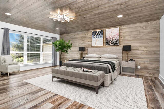 bedroom with ceiling fan with notable chandelier, hardwood / wood-style flooring, wood ceiling, and wood walls