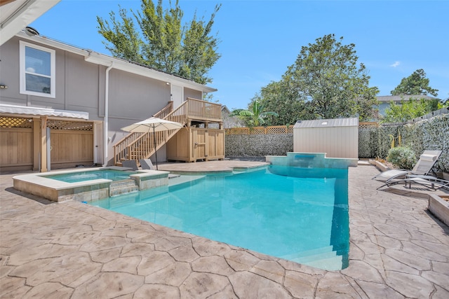 view of pool with an in ground hot tub, a storage unit, and a patio area