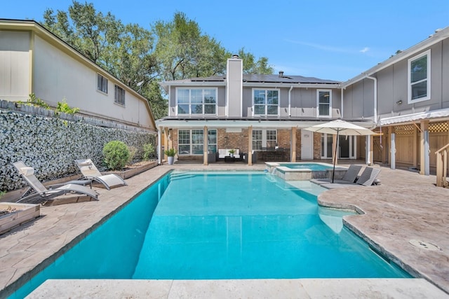 view of swimming pool featuring a patio and an in ground hot tub