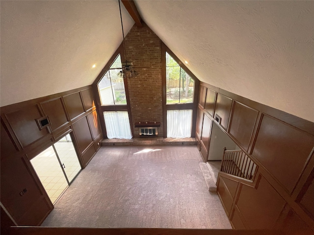 bonus room with carpet floors, a fireplace, lofted ceiling with beams, and ceiling fan