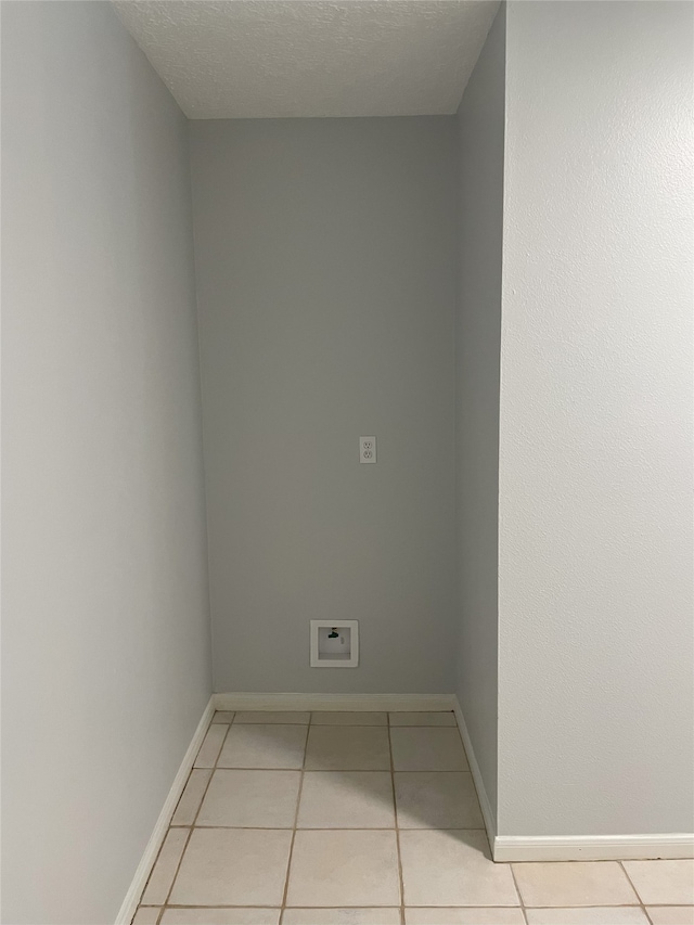 tiled empty room with a textured ceiling