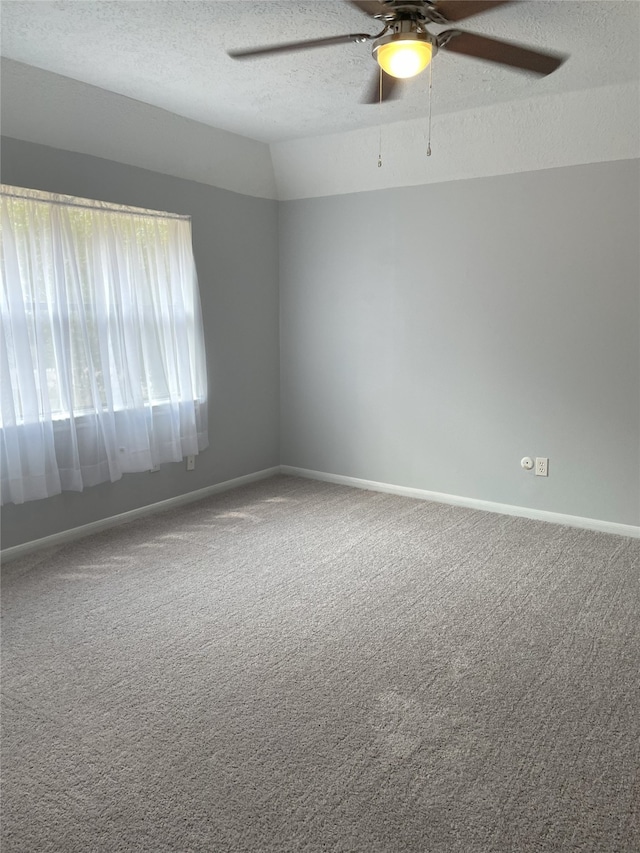 carpeted spare room with lofted ceiling, ceiling fan, and a textured ceiling