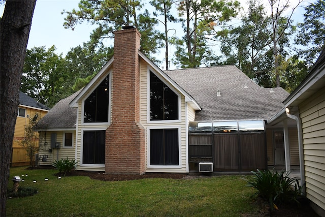 rear view of house featuring a lawn