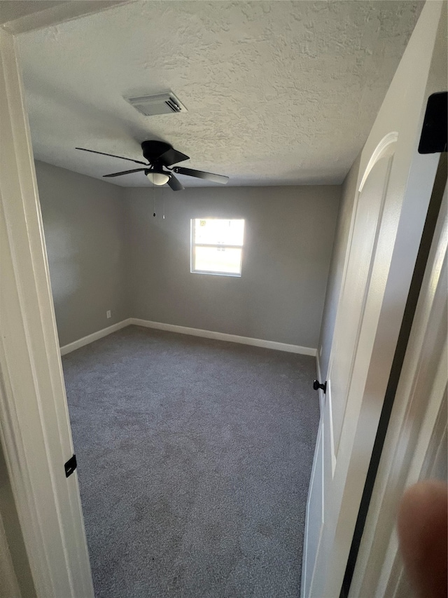 spare room featuring carpet and ceiling fan