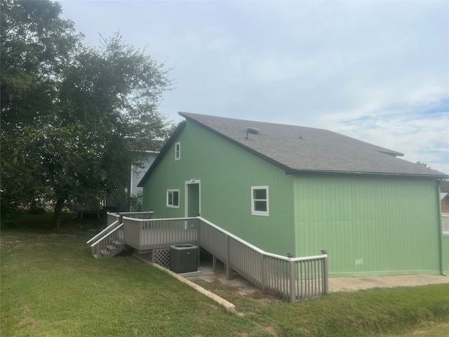 view of property exterior with a wooden deck, central AC unit, and a yard