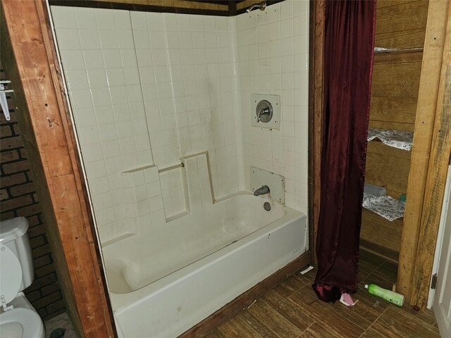 bathroom with shower / bath combination with curtain and toilet