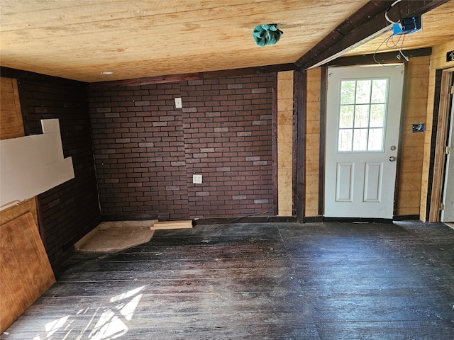 entryway featuring vaulted ceiling, dark hardwood / wood-style flooring, and brick wall