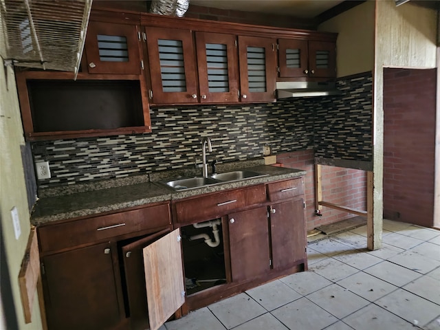 kitchen with light tile patterned floors, exhaust hood, sink, and tasteful backsplash