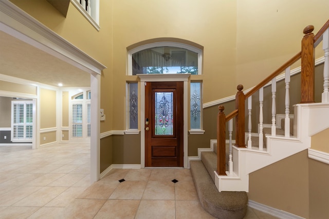 foyer with a towering ceiling and light tile patterned floors