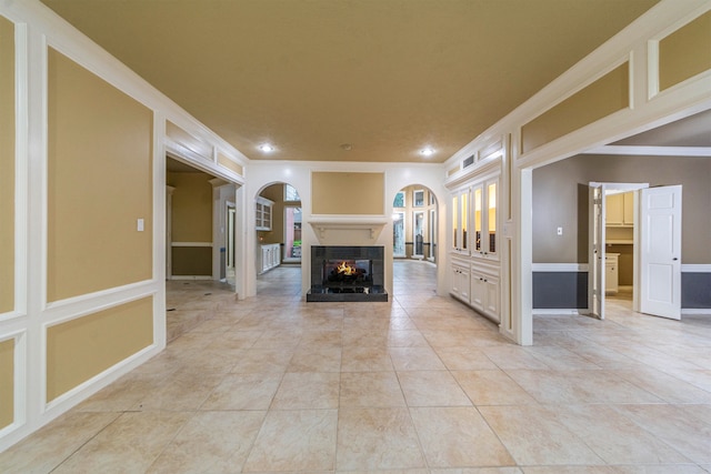 interior space with a multi sided fireplace, light tile patterned floors, and crown molding