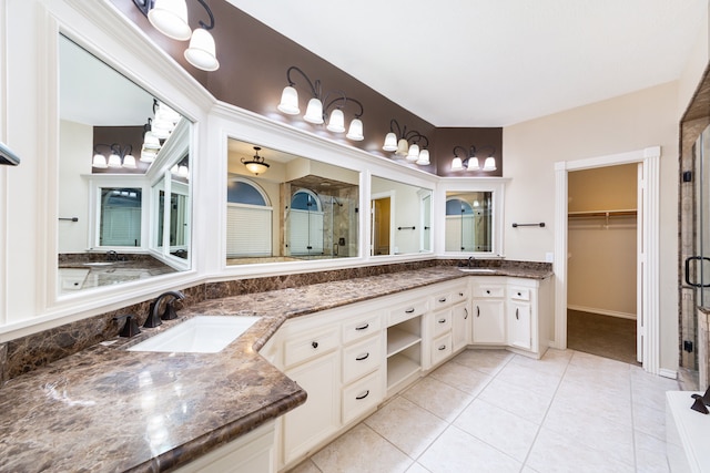 bathroom featuring tile patterned floors, an enclosed shower, and vanity