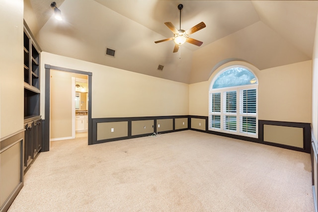 carpeted empty room featuring vaulted ceiling and ceiling fan