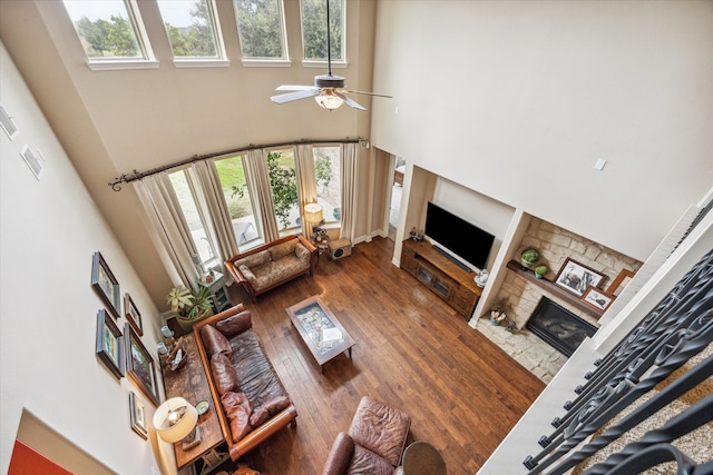 living room featuring a fireplace, a towering ceiling, and a wealth of natural light