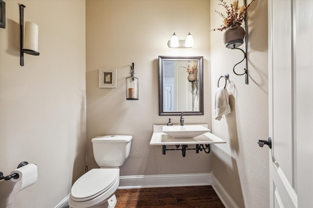 bathroom with wood-type flooring, sink, and toilet