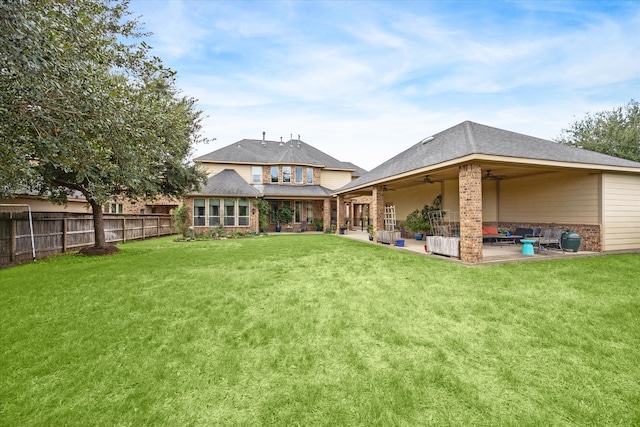 back of house with ceiling fan, a yard, and a patio area