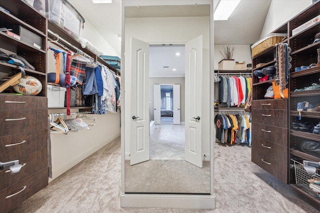 walk in closet with light carpet