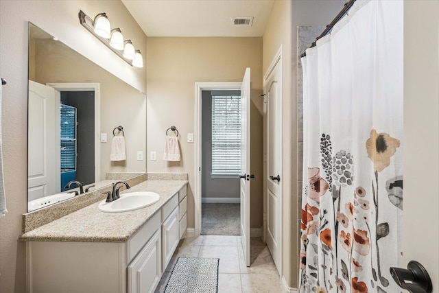 bathroom with a shower with curtain, vanity, and tile patterned floors