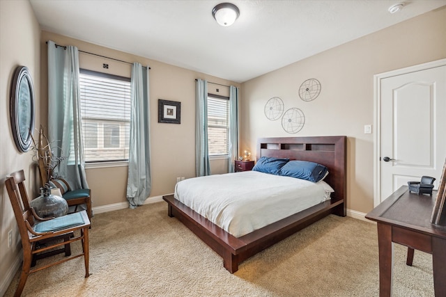 bedroom with light colored carpet and multiple windows