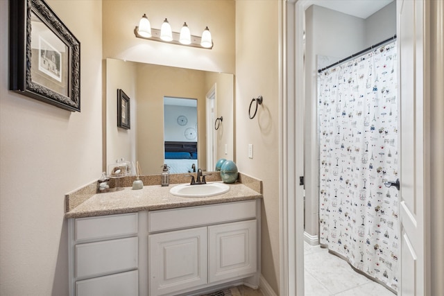 bathroom featuring tile patterned flooring, vanity, and curtained shower