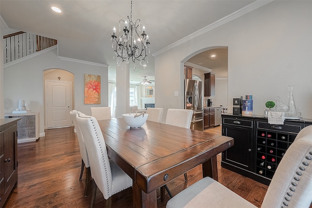 dining space featuring ceiling fan with notable chandelier, crown molding, and dark hardwood / wood-style flooring