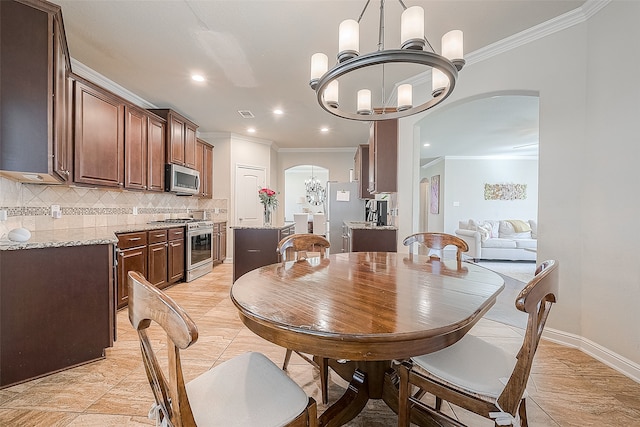 dining space featuring crown molding and a chandelier