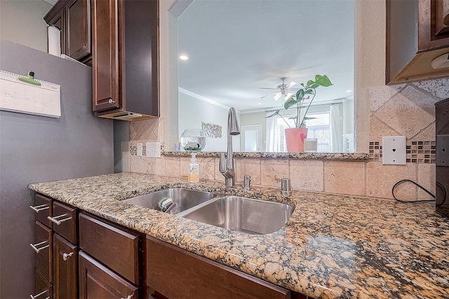 kitchen with sink, decorative backsplash, fridge, crown molding, and ceiling fan