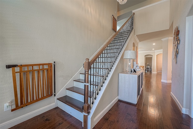 stairway with wood-type flooring and a high ceiling