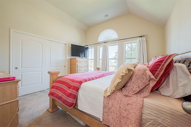 bedroom with light carpet, vaulted ceiling, and a closet